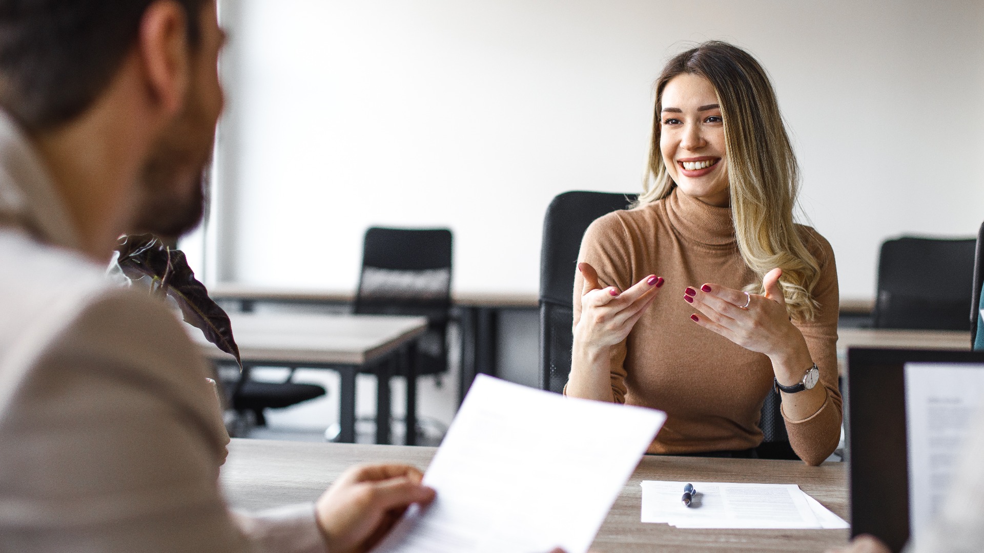 Glückliche Bewerberin bei einem Vorstellungsgespräch im Büro.